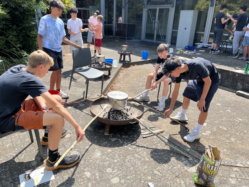Feuer 01 - Teilnehmer backen Stockbrot während ihr Eintopf gart